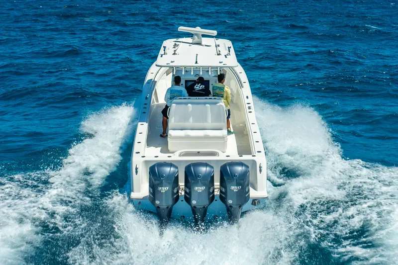 Slide: The Image of 2016 Invincible 39 boat cruising on open blue water with triple engines. - 17