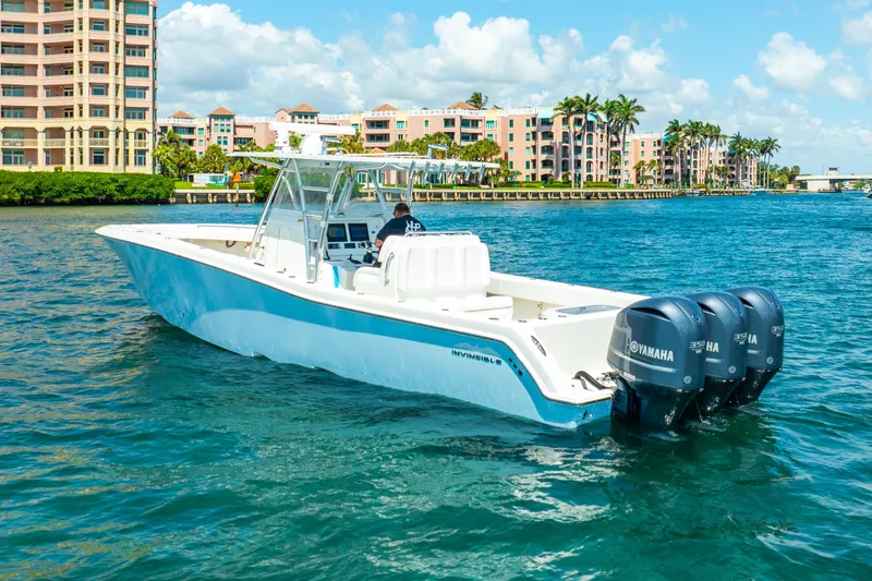 Slide: The Image of 2016 Invincible 39 boat with triple Yamaha engines on a sunny waterfront. - 19