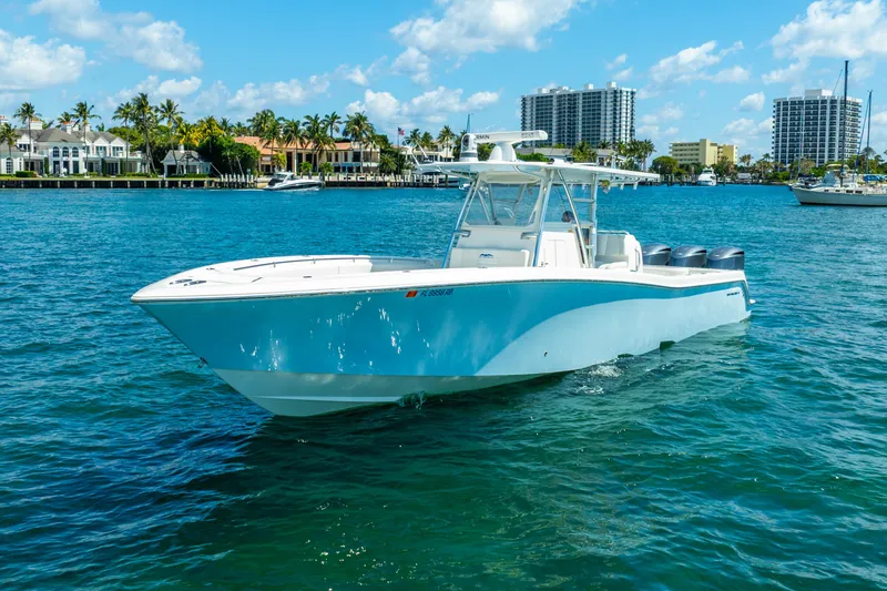 Slide: The Image of 2016 Invincible 39 boat cruising on a sunny day near waterfront homes. - 2