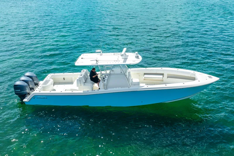 Slide: The Image of 2016 Invincible 39 boat on clear blue water, featuring dual outboard engines. - 24