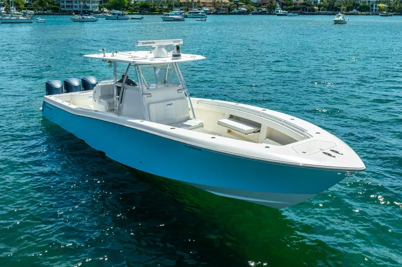 Slide: The Image of 2016 Invincible 39 boat on clear blue water with triple outboard engines. - 25