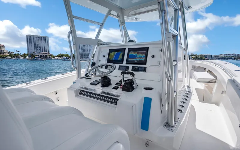 Slide: The Image of 2016 Invincible 39 boat cockpit with modern navigation equipment, steering wheel, and ocean view. - 35