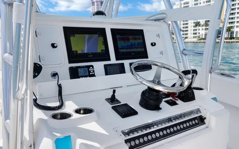Slide: The Image of Control panel of a 2016 Invincible 39 boat with navigation screens and steering wheel. - 40
