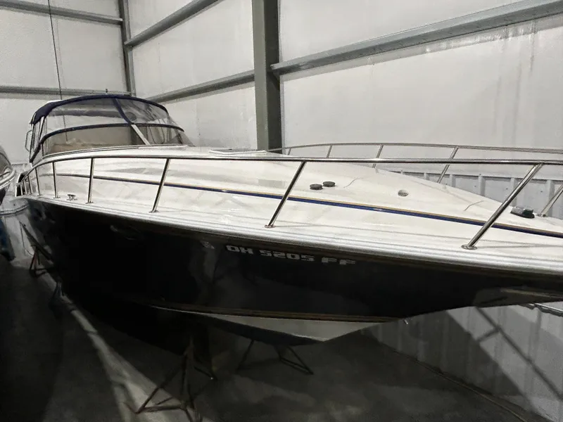 Slide: The Image of 2002 Fountain 38 Express Cruiser in storage, sleek design, white and navy exterior. - 1
