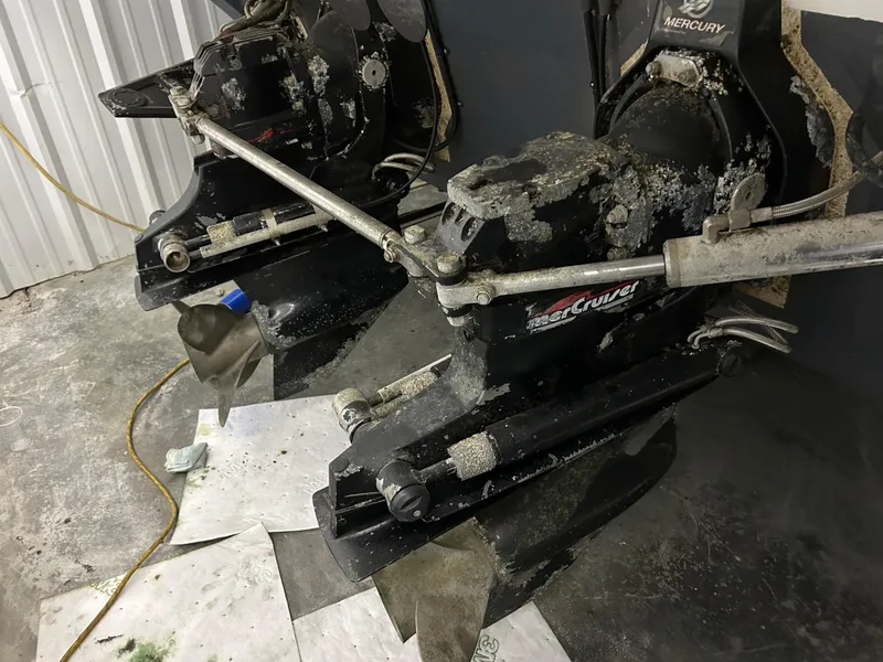 Slide: The Image of Outboard motors of a 2002 Fountain 38 Express Cruiser with visible wear and marine growth. - 4