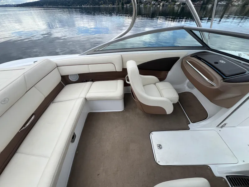 Slide: The Image of Interior of a 2009 Cobalt 230 boat with beige seating and lake view. - 15