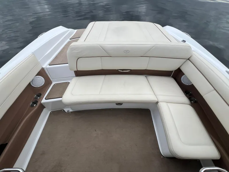Slide: The Image of 2009 Cobalt 230 boat interior with beige and brown seating, on calm water. - 16
