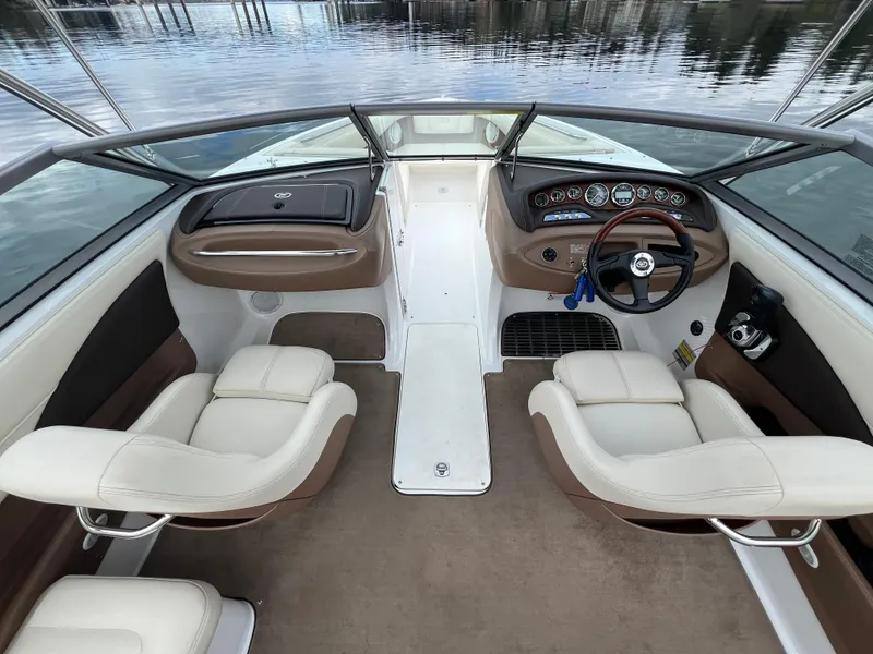 Slide: The Image of Interior of a 2009 Cobalt 230 boat with beige seating and sleek dashboard. - 18