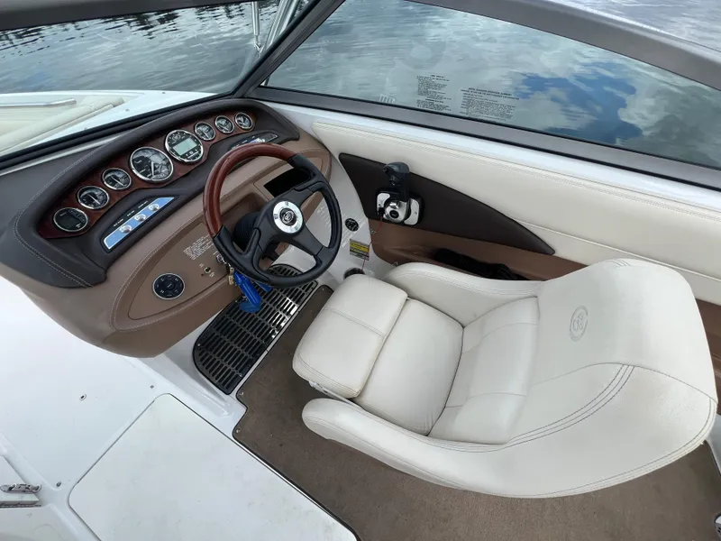 Slide: The Image of 2009 Cobalt 230 boat cockpit with steering wheel, gauges, and white captain's chair. - 20