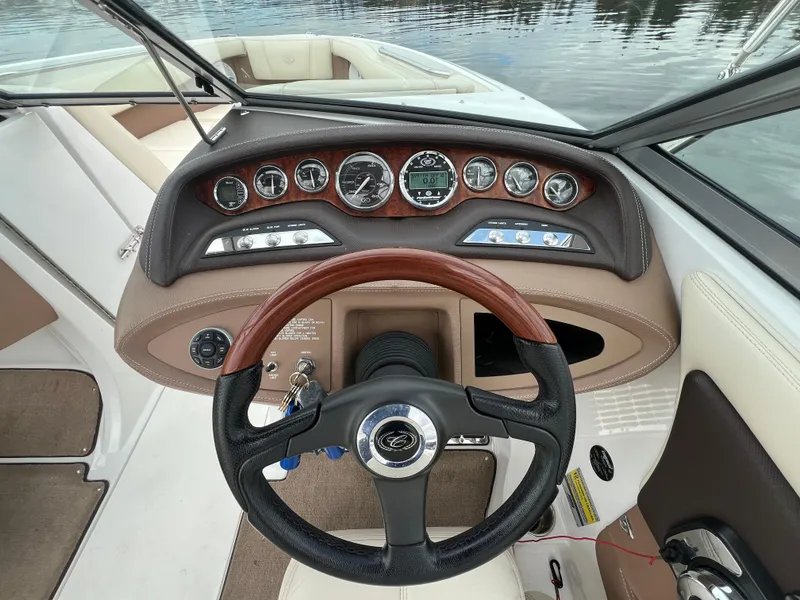Slide: The Image of 2009 Cobalt 230 boat dashboard with wood-trimmed steering wheel and instrument panel. - 21