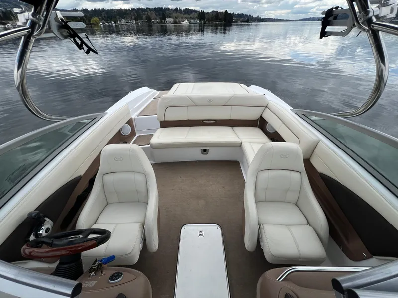 Slide: The Image of 2009 Cobalt 230 boat interior with white seating on a calm lake. - 22