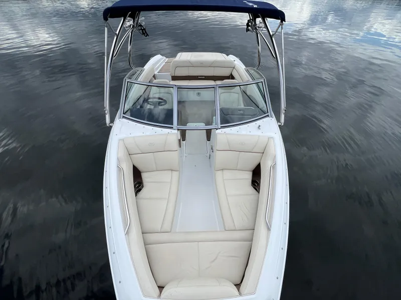 Slide: The Image of 2009 Cobalt 230 boat with white seating and blue canopy on calm water. - 24