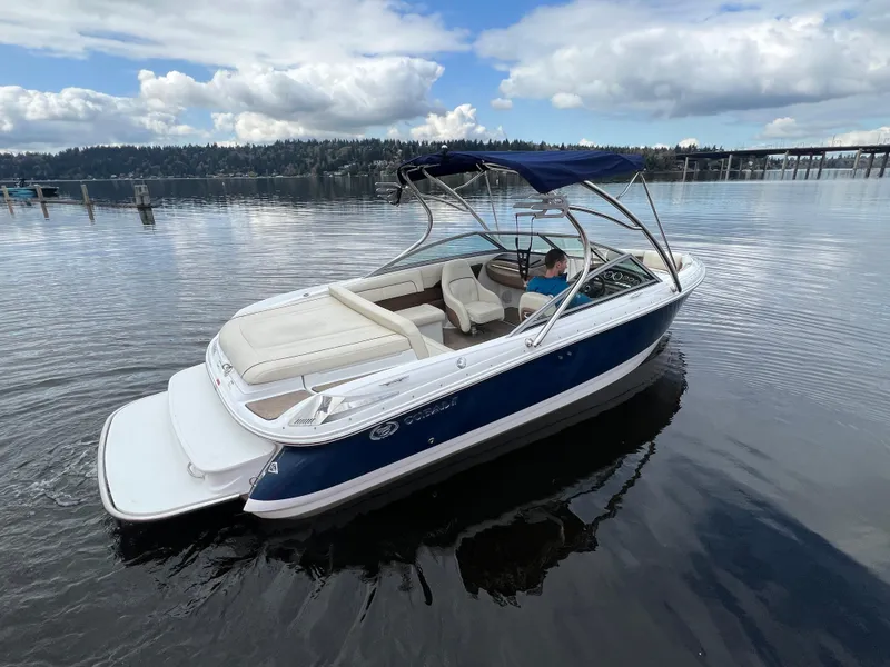 Slide: The Image of 2009 Cobalt 230 boat on calm lake with scenic forest backdrop. - 5