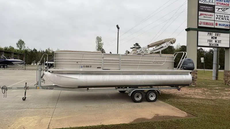 Slide: The Image of 2016 Starcraft EX23 R pontoon boat on trailer in dealership lot. - 1