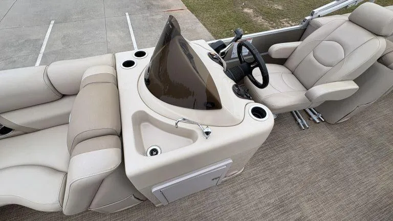 Slide: The Image of 2016 Starcraft EX23 R boat interior with beige seating and steering console. - 13