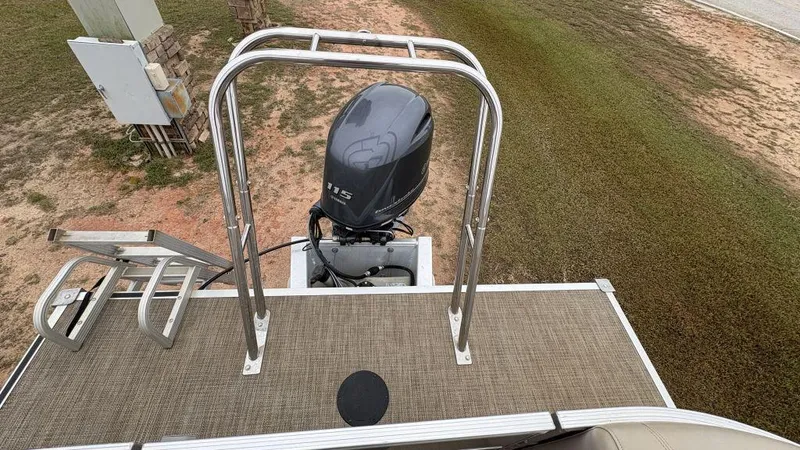 Slide: The Image of 2016 Starcraft EX23 R boat with outboard motor and swim ladder on grassy terrain. - 9