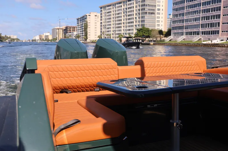 Slide: The Image of Luxurious 2025 Skipper-BSK 38 boat with orange seating, cruising near waterfront buildings. - 7