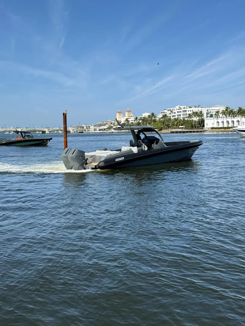Slide: The Image of 2025 Skipper-BSK 38 boat cruising on a sunny day near waterfront buildings. - 13