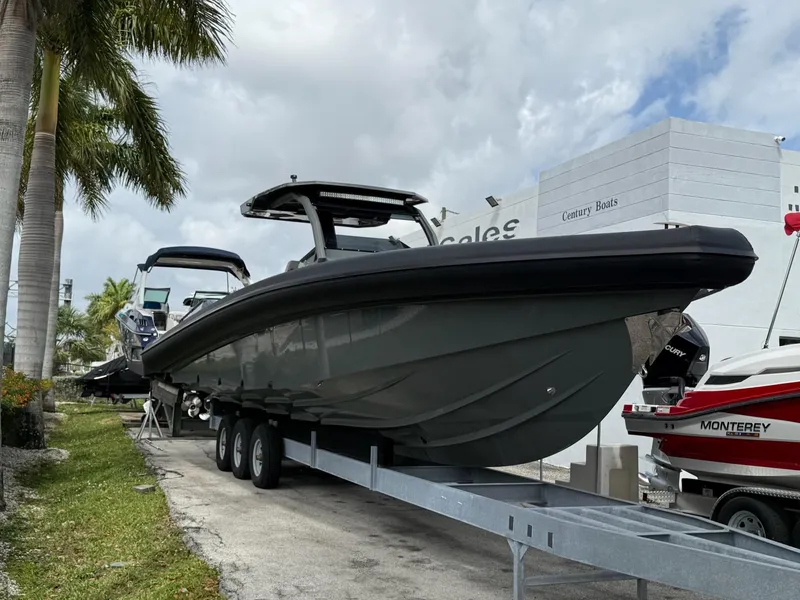 Slide: The Image of 2025 Skipper-BSK 38 boat on trailer, displayed outdoors near palm trees. - 14