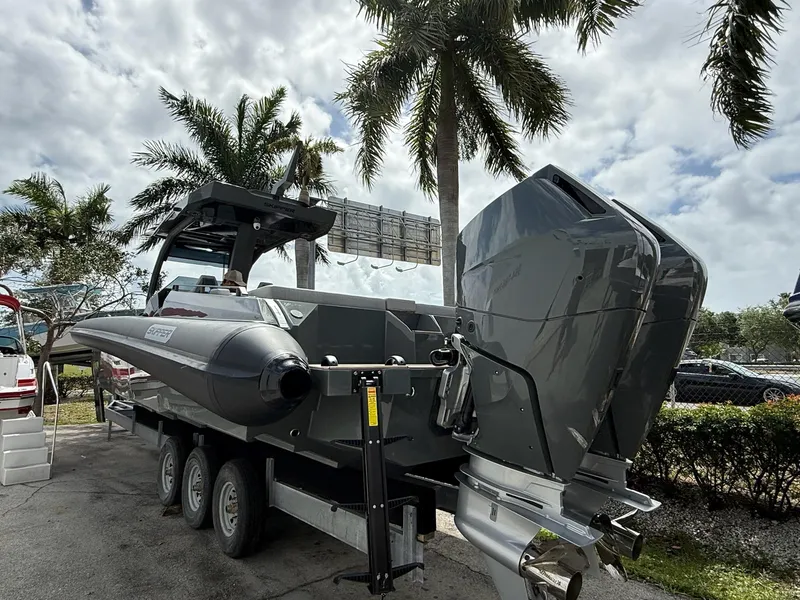 Slide: The Image of 2025 Skipper-BSK 38 boat on trailer, parked under palm trees, showcasing sleek design. - 15