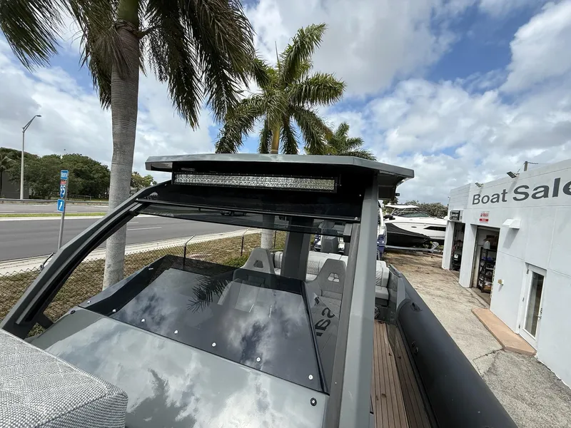 Slide: The Image of 2025 Skipper-BSK 38 boat at dealership, palm trees, cloudy sky, modern design. - 19