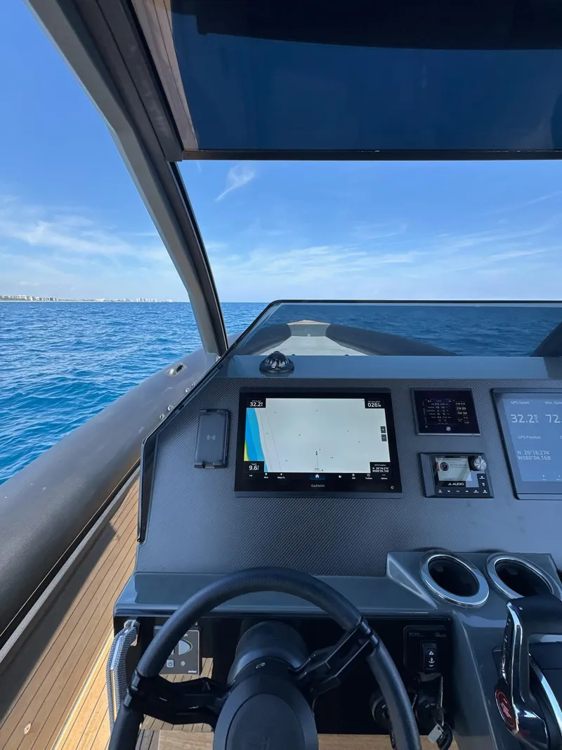 Slide: The Image of Helm of 2025 Skipper-BSK 38 boat with navigation system, steering wheel, and ocean view. - 2