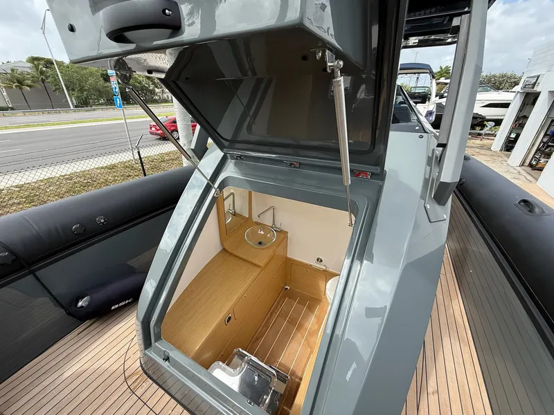 Slide: The Image of 2025 Skipper-BSK 38 boat interior with open hatch, showcasing compact wooden cabin space. - 21