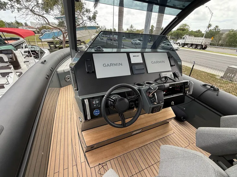 Slide: The Image of 2025 Skipper-BSK 38 boat cockpit with Garmin navigation, modern steering, and wood finish. - 25
