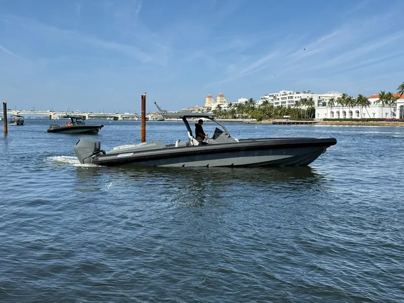 Slide: The Image of 2025 Skipper-BSK 38 boat cruising on a sunny day in a scenic waterfront area. - 6