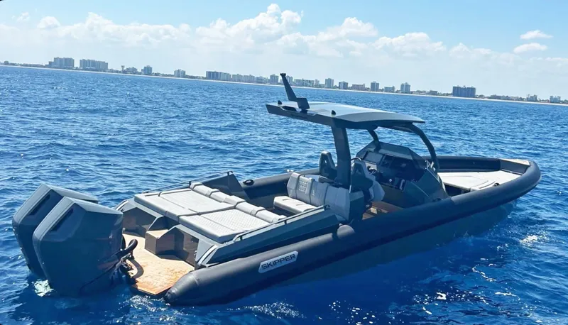 Slide: The Image of 2025 Skipper-BSK 38 boat on open water, clear sky, city skyline in background. - 1