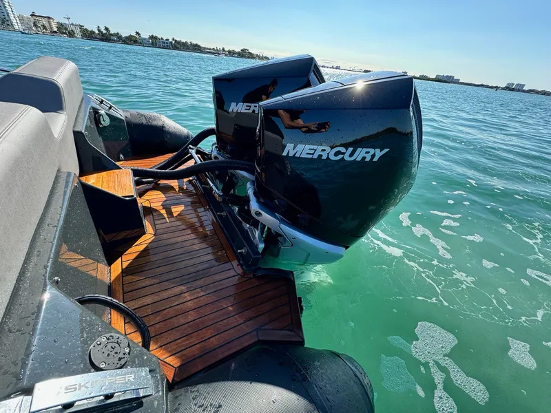 Slide: The Image of 2025 Skipper-BSK 34 boat with dual Mercury outboard engines on clear water. - 13