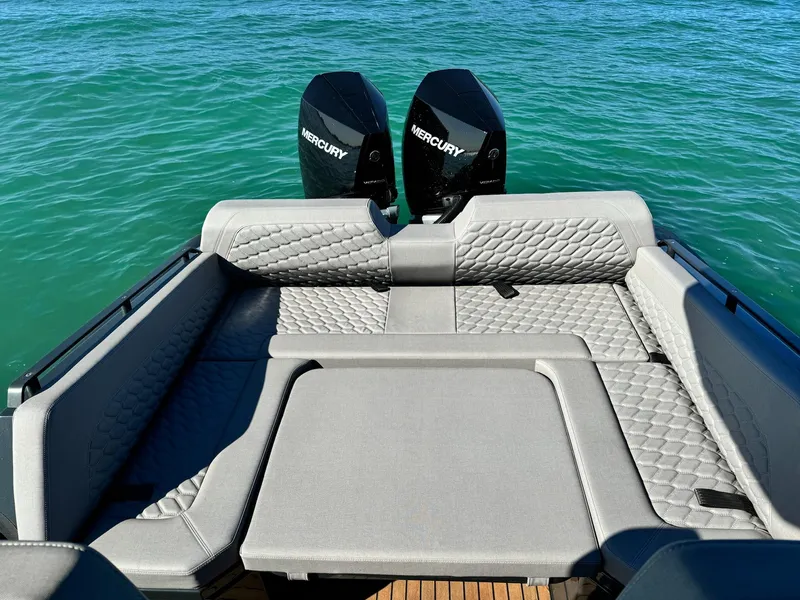 Slide: The Image of 2025 Skipper-BSK 34 boat with Mercury engines, featuring luxurious seating on clear blue water. - 12