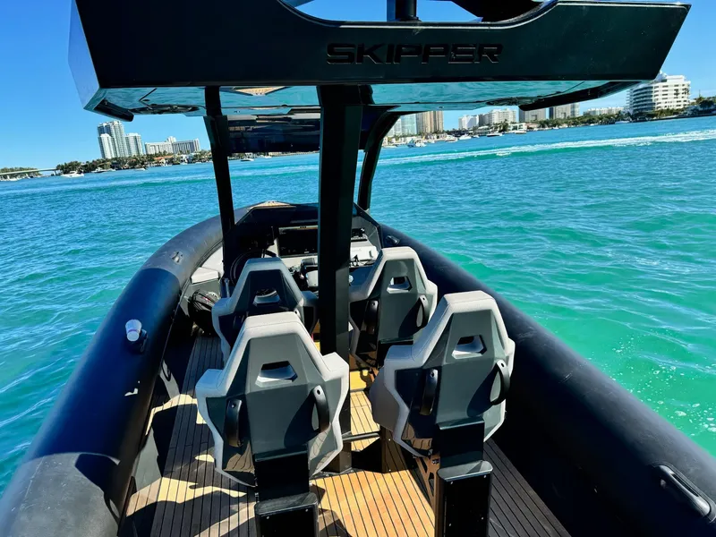 Slide: The Image of Skipper-BSK 34 boat, 2025 model, on turquoise water with modern seating. - 14