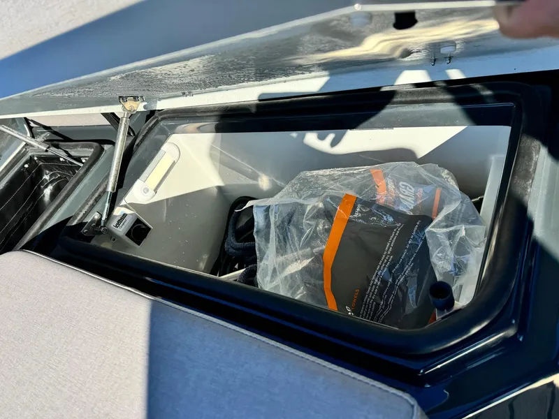 Slide: The Image of Storage compartment in a 2025 Skipper-BSK 34 boat, containing a plastic-wrapped item. - 17