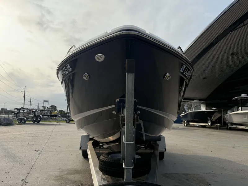 Slide: The Image of 2015 Chaparral 257 SSX boat on trailer, parked outdoors under cloudy sky. - 4