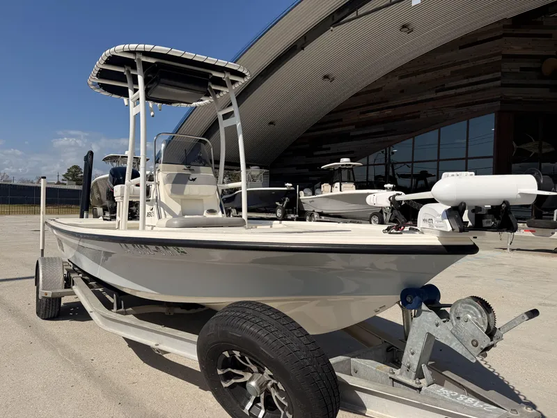 Slide: The Image of 2021 Mako 18 LTS boat on trailer, parked outside a modern building. - 16