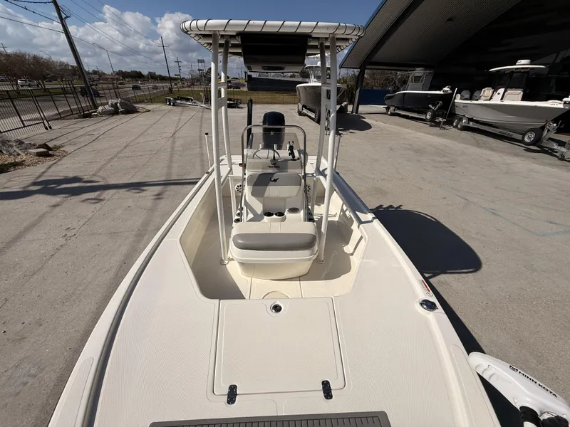 Slide: The Image of 2021 Mako 18 LTS boat with center console, parked outdoors under clear skies. - 19