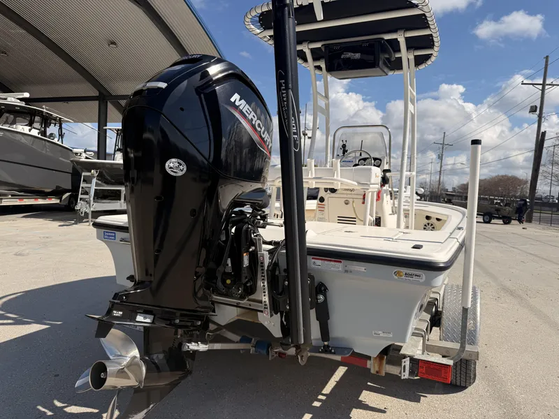 Slide: The Image of 2021 Mako 18 LTS boat with Mercury engine, parked on a trailer under a canopy. - 20