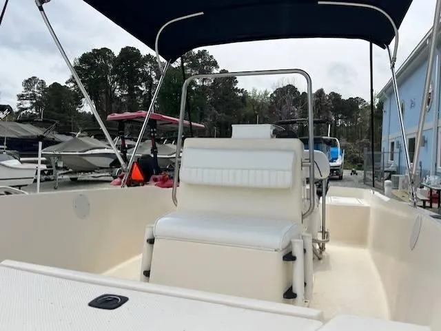 Slide: The Image of 2003 Key West 1720 CC boat with canopy, docked near other boats. - 6