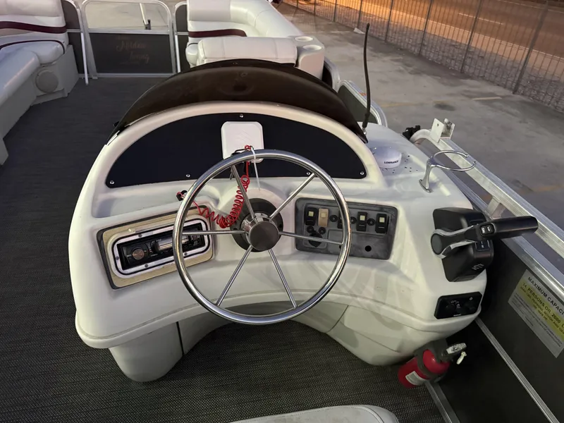 Slide: The Image of Steering console of a 2008 South Bay 25 boat with controls and fire extinguisher. - 10