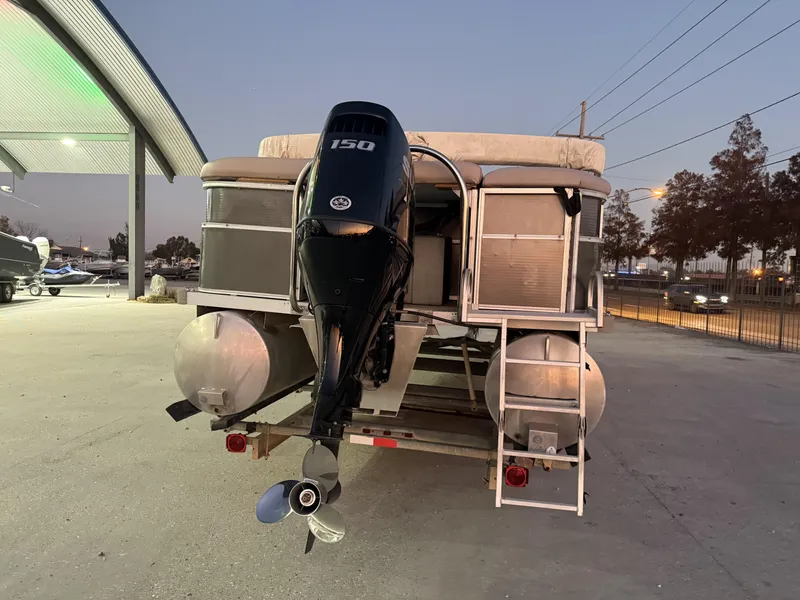 Slide: The Image of 2008 South Bay 25 pontoon boat with 150 HP outboard motor at dusk. - 2
