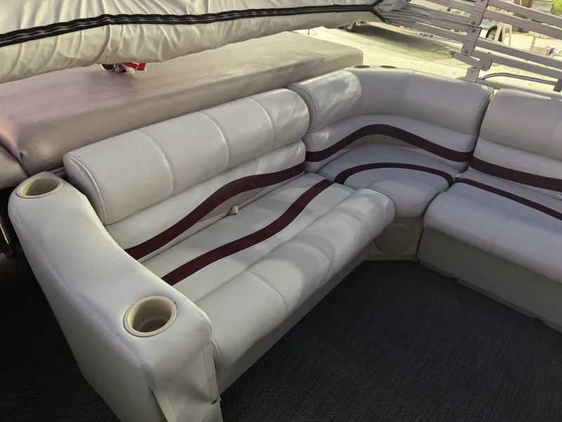 Slide: The Image of 2008 South Bay 25 boat interior with white and maroon seating, cup holders, and carpeted floor. - 3