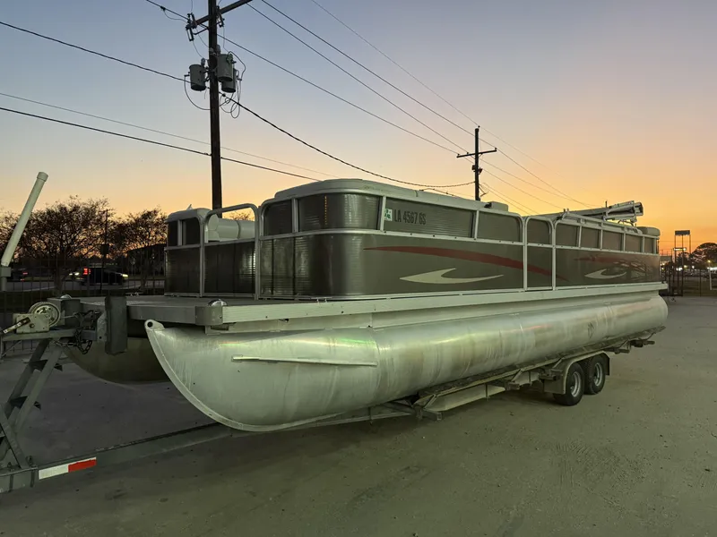 Slide: The Image of 2008 South Bay 25 pontoon boat on trailer at sunset, parked outdoors. - 8
