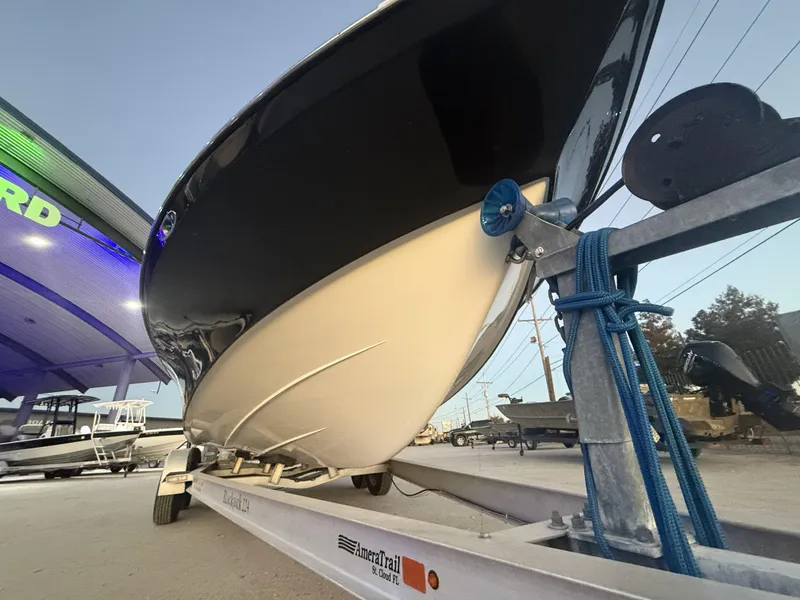 Slide: The Image of 2013 BlackJack 224 boat on trailer, parked outside dealership at dusk. - 14