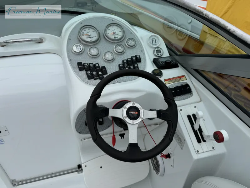 Slide: The Image of 2002 Baja 292 Islander boat dashboard with steering wheel and control panel. - 13