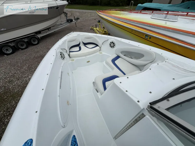 Slide: The Image of 2002 Baja 292 Islander boat interior with white and blue seating, docked outdoors. - 18