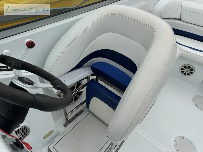 Slide: The Image of 2002 Baja 292 Islander boat interior with white and blue seating, steering wheel, and speaker. - 22