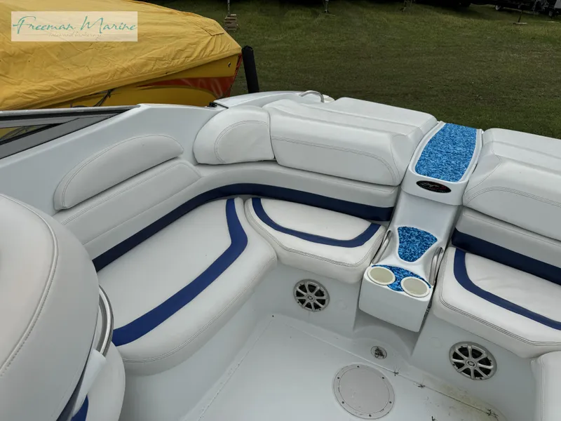 Slide: The Image of 2002 Baja 292 Islander boat interior with white and blue seating, cup holders, and speakers. - 23