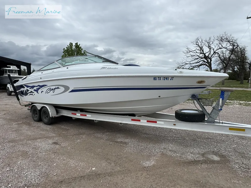 Slide: The Image of 2002 Baja 292 Islander boat on trailer, parked outdoors under cloudy sky. - 4