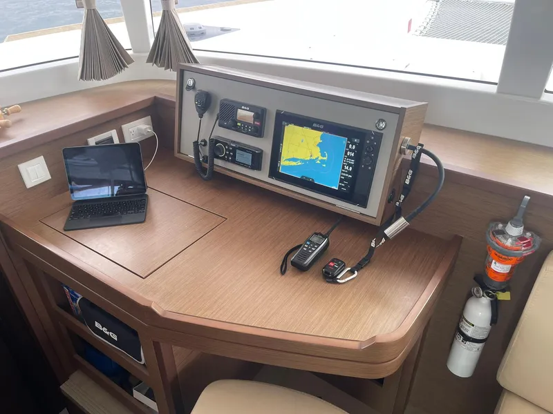 Slide: The Image of Navigation station of 2019 Lagoon 450 F catamaran with electronics and safety equipment. - 11